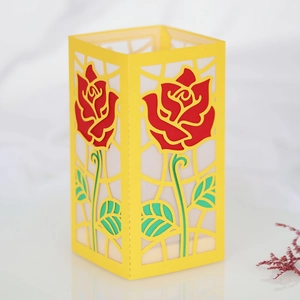 Dettaglio macro della lanterna di carta gialla con rosa rossa 3D e motivo traforato