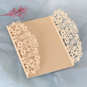Detail of champagne gold laser-cut invitation sleeve with floral and butterfly patterns