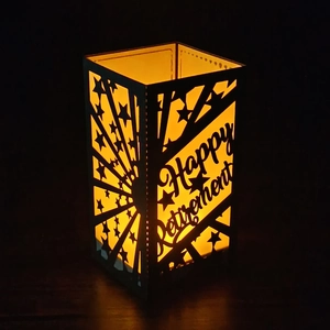 Happy Retirement black lantern with star cutout patterns and warm yellow glowing light