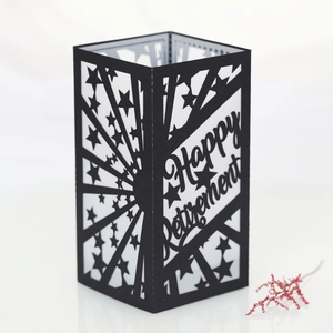 Detail of laser-cut Happy Retirement black paper lantern shade with star patterns