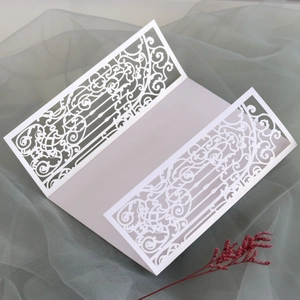 Detailed laser-cut gatefold wedding invitation sleeve with intricate scroll patterns