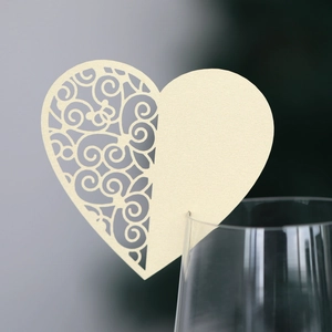 Detail of a beige heart-shaped laser-cut place card attached to a wine glass rim