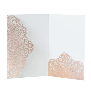 Detail of rose gold glitter laser cut wedding invitation with elegant hollow pattern