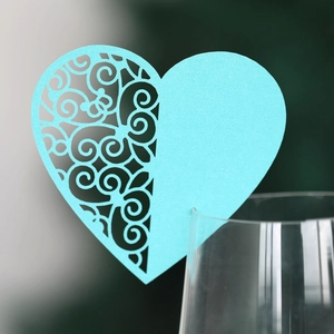 Light blue heart laser-cut place card with butterfly pattern on a wine glass rim