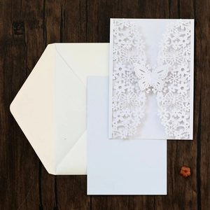 Detailed laser-cut white wedding invitation set with butterfly motif and envelopes