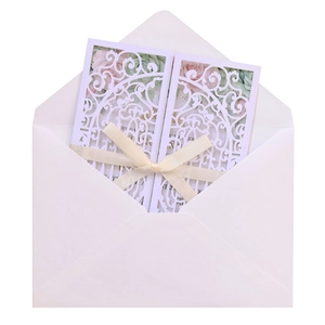 Détail du faire-part de mariage découpé au laser blanc avec insert floral et ruban crème