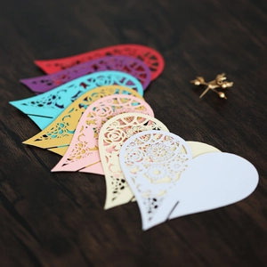 Macro detail of laser-cut hollow rose patterns on multicolored heart-shaped paper cards