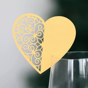 Golden heart place card with laser-cut vine patterns for elegant wedding table decor