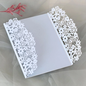 Detail of laser-cut white wedding invitation with hollow butterfly and floral pattern