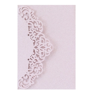 Detail of pink glitter invitation card featuring intricate laser-cut floral patterns