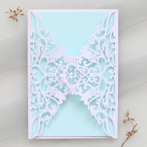 Close-up of laser-cut butterfly wedding invitation with elegant floral lace details