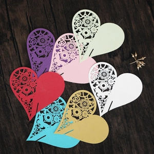 Detailed laser-cut heart place cards in various colors for wedding wine glass decor
