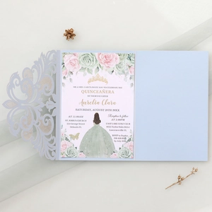 Detailed laser-cut light blue Quinceañera invitation with floral inner card and crown motif