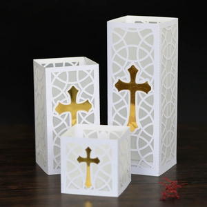 Three white paper lantern luminaries with gold crosses and laser-cut geometric patterns