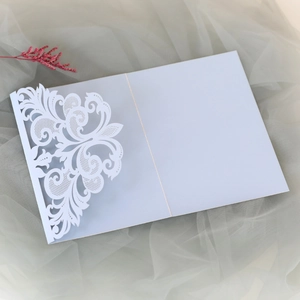 Detailed laser-cut lace floral pattern on elegant white wedding invitation cover