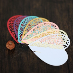 Macro detail of laser-cut heart place cards in various colors on a wooden surface