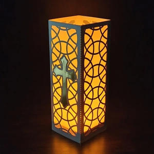 Laser-cut white cross lantern with warm glowing LED light for sacred event decoration