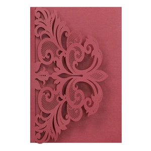 Detailed laser-cut red pearlescent cardstock with intricate scrollwork for wedding invitations