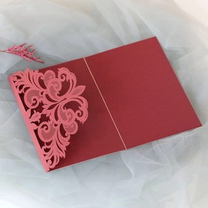 Close-up of laser-cut lace floral pattern on elegant burgundy wedding invitation card