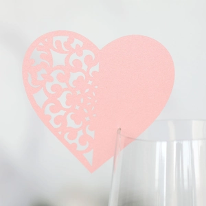 Detailed laser-cut heart shape place card in pink pearl paper on glass rim