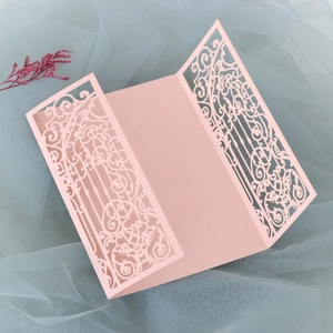 Detailed laser-cut floral patterns on a pink tri-fold wedding invitation cover