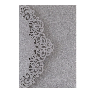 Close-up of silver glitter laser-cut lace design on wedding invitation card cover