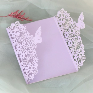 Close-up of laser-cut lavender butterfly invitation with intricate floral details
