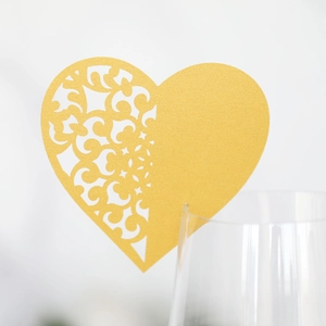 Detail of laser-cut gold heart-shaped place card for wine glasses at wedding events