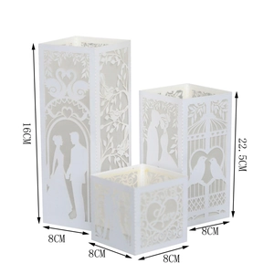 Three white laser-cut paper lantern covers with wedding couple and swan motifs