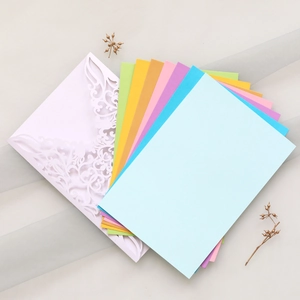 Close-up of laser-cut floral invitations with multi-colored inserts on gauze background
