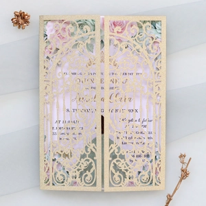 Close-up of laser-cut champagne gold glitter invitation with elegant floral inner page