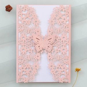 Macro detail of laser-cut butterfly and floral pattern on pink wedding invitation card