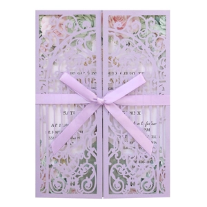 Détail d'invitation de mariage découpée au laser avec nœud en soie et motif floral