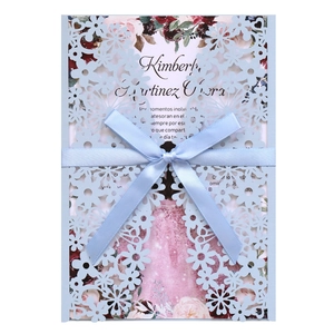 Detailed laser-cut blue wedding invitation with elegant floral insert and silk bow