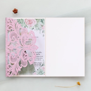 Detail of pink glitter laser-cut lace wedding invitation with floral printed inner card