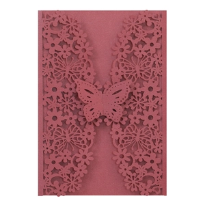 Close-up of laser-cut butterfly invitation with intricate floral details and pearlescent finish