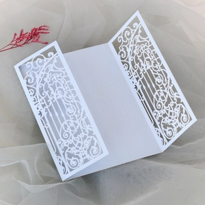 Detail of laser-cut white wedding invitation with elegant hollow scrollwork on mesh fabric