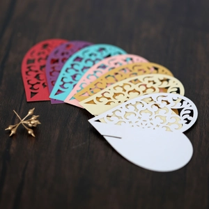 Detailed laser-cut heart place cards in multiple colors for wedding table decor