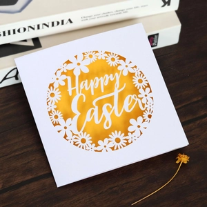 Détail de la carte d'invitation Happy Easter découpée au laser avec motifs floraux sur bois