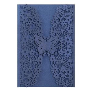 Detail of laser-cut navy blue wedding invitation card with pearlescent butterfly pattern