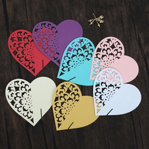 Laser-cut heart-shaped place cards for wine glasses in multiple colors on wood surface