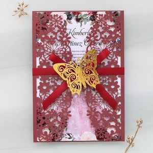 Elegant burgundy laser cut wedding invitation with golden butterfly and red ribbon