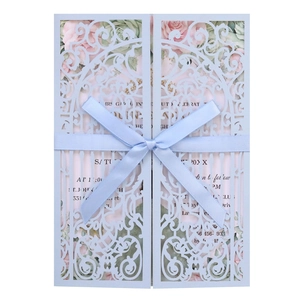Détail d'invitation découpée au laser bleu clair avec ruban et motif floral chic