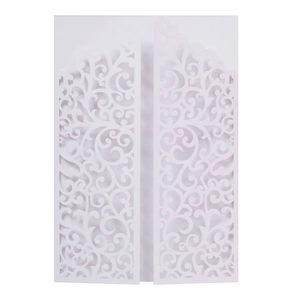 Detail of laser-cut white wedding invitation featuring elegant European scroll patterns