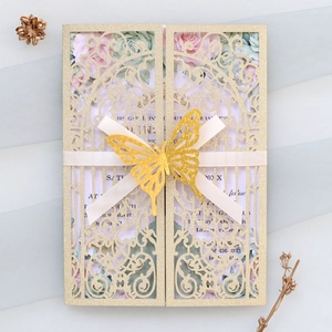 Detail of gold glitter laser-cut wedding invitation with floral insert and 3D butterfly