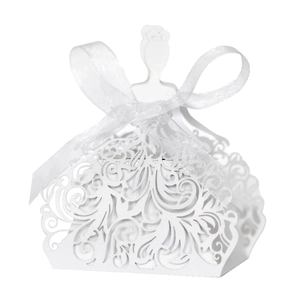 Detail of laser-cut wedding dress candy box with white ribbon and intricate hollow pattern