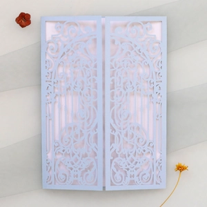 Détail d'invitation de mariage découpée au laser avec motif floral bleu et insert rose