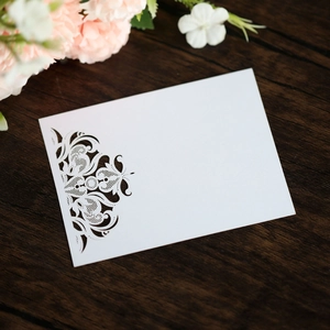Detailed laser-cut lace texture on premium white cardstock for wedding invitations