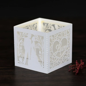Detailed laser-cut white paper lantern with romantic bride and groom silhouette and Love motif