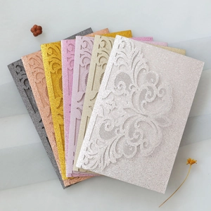 Macro shot of glitter laser-cut lace invitation cards in multiple metallic colors